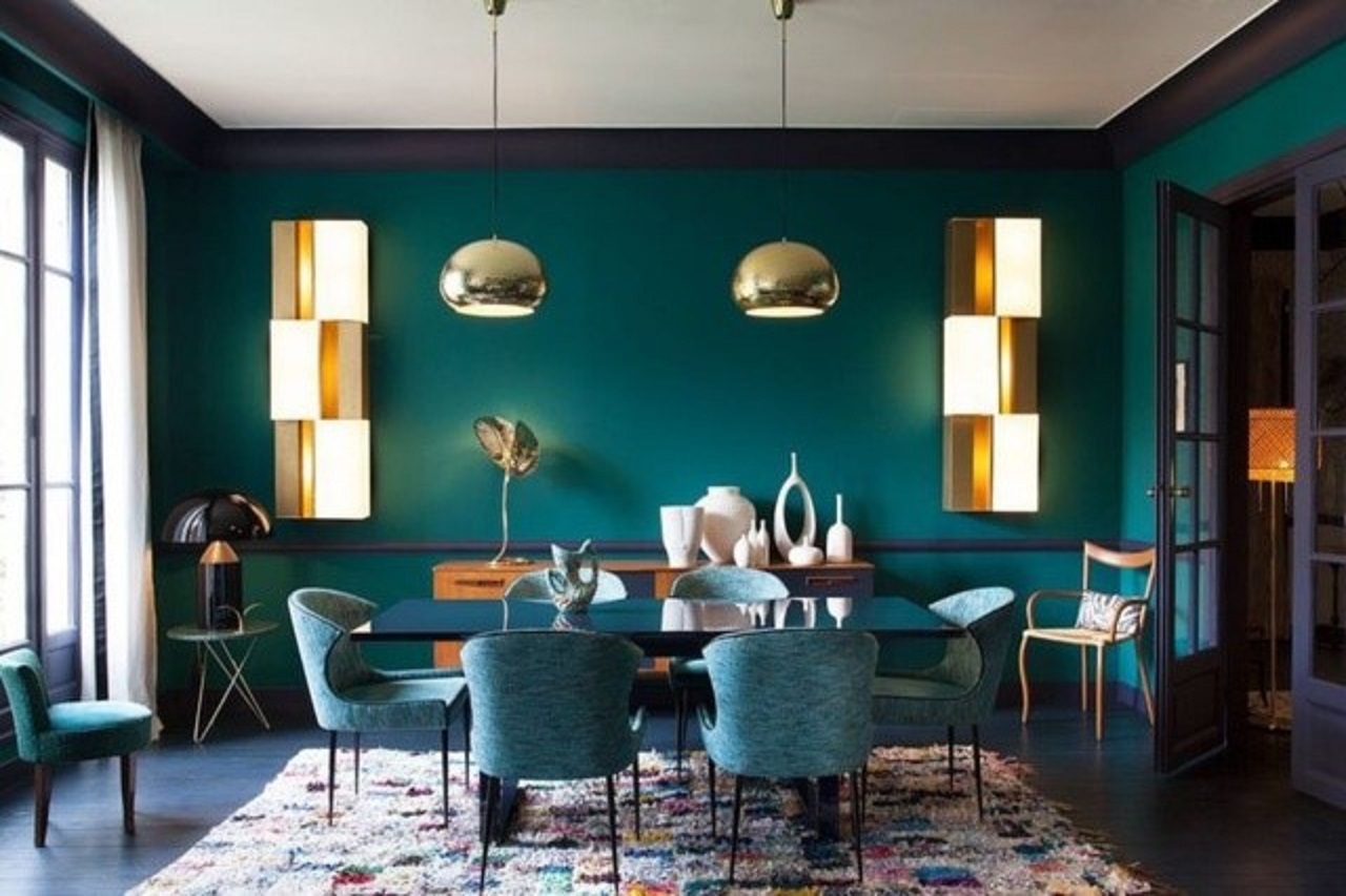Phòng ăn đơn sắc táo bạo được thực hiện trong màu xanh ngọc và màu xanh lá cây, với những điểm nhấn kim loại và với một tấm thảm đầy màu sắc.