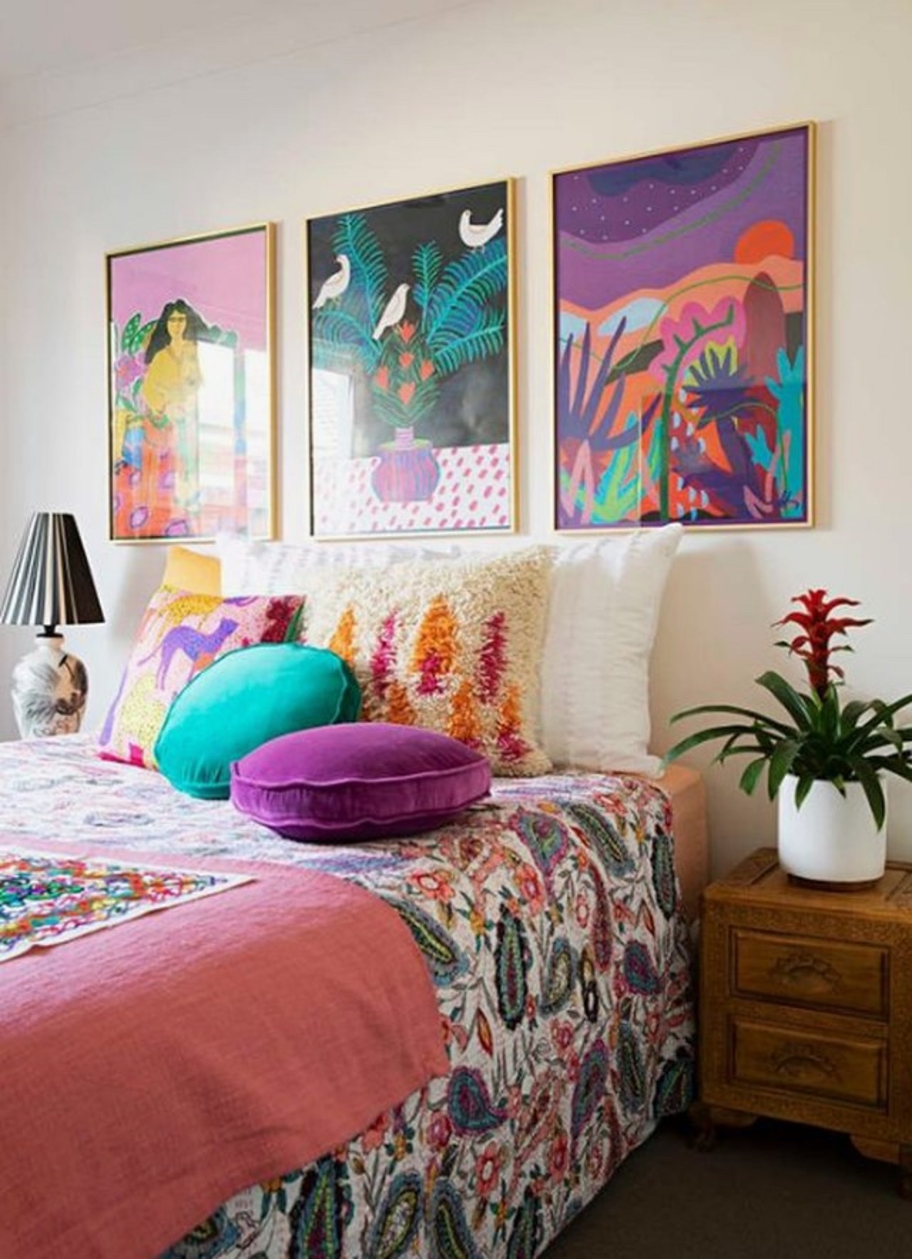 Phòng ngủ đầy màu sắc được tạo nên từ màu ngọc lam và màu tím, với những bức tranh nghệ thuật đầy màu sắc trên tường, họa tiết tropical được in trên vỏ chăn.