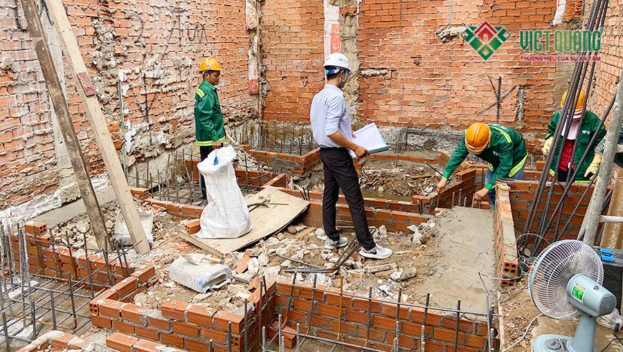Kỹ sư Việt Quang đang hướng dẫn và kiểm tra công nhân triển khai lắp đặt thép móng theo bản vẽ thiết kế