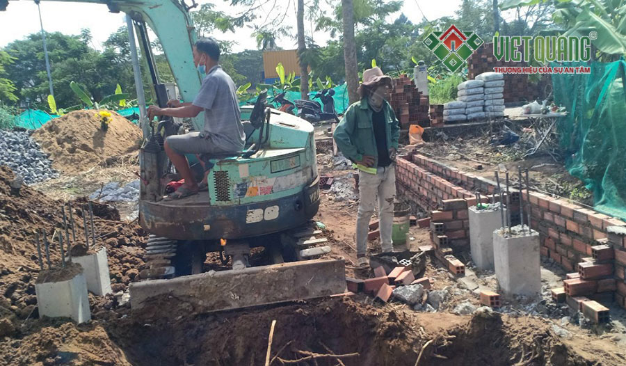 Công nhân Việt Quang đang dùng máy móc để đào móng