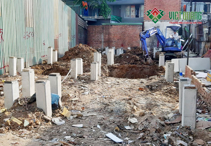 Hình ảnh cọc bê tông đã được ép xuống nền móng, Việt Quang đang tiến hành đào móng nhà bằng máy múc