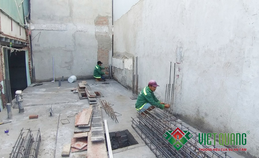 Công nhân Việt Quang đang định vị tim cột, kiểm tra kích thước cột, tường xây trước khi tiến hành xây tường bao xung quanh