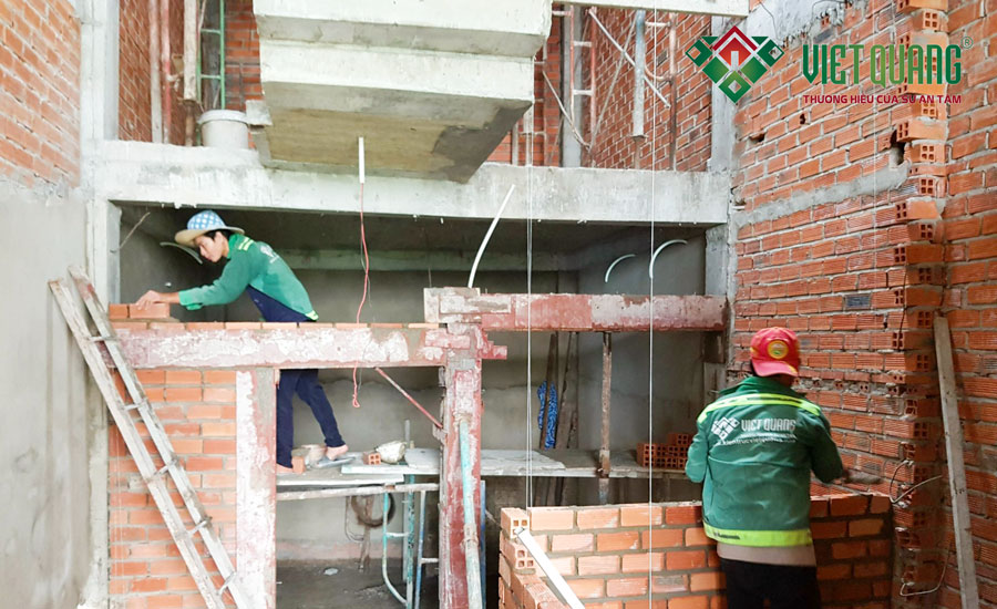 Công nhân Việt Quang Group đang xây tường phân chia phòng chức năng tại tầng 2 của ngôi nhà